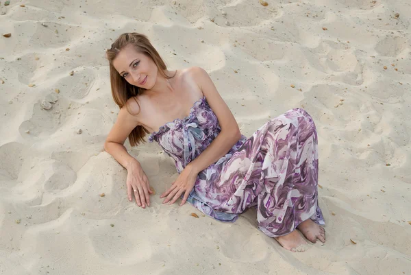 Hermosa mujer elegante sentarse en la arena — Foto de Stock