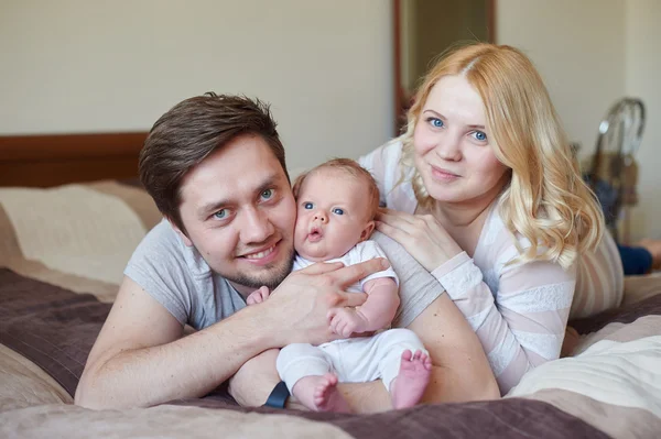 Padres de familia atractivos y jóvenes felices con bebé recién nacido —  Fotos de Stock