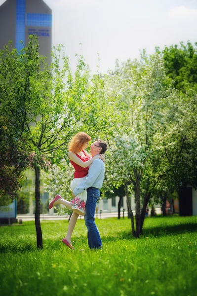 Young couple walking in the blossoming spring garden — Stock Photo, Image