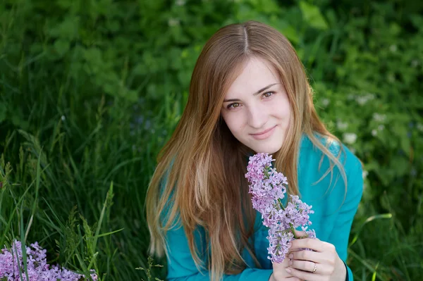 Belle femme avec une branche de lilas dans le jardin du printemps — Photo