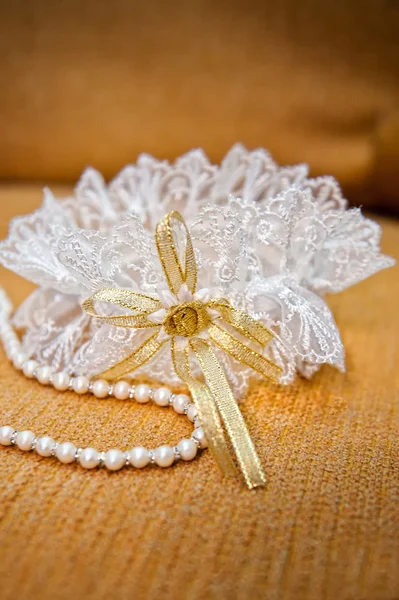 Elegant bride garter and pearls necklace — Stock Photo, Image