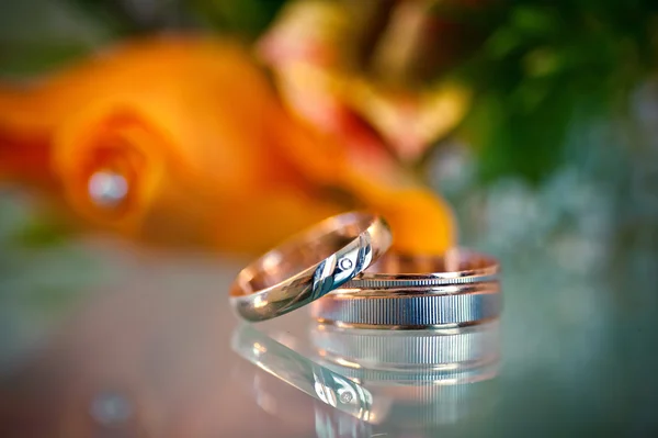 Due bellissimi anelli d'oro su sfondo arancione sfocato — Foto Stock