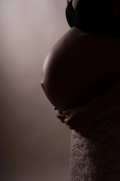 घराच्या खिडकीजवळ मोठ्या बेअर ट्यूमीसह आनंदी गर्भवती महिलेचा सिल्हूट — स्टॉक फोटो, इमेज
