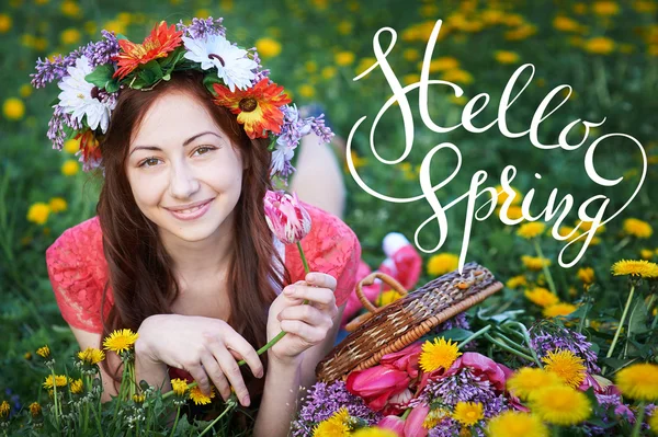 Young woman enjoying smell in a flowering spring garden with letters Hello sprint — Stock Photo, Image