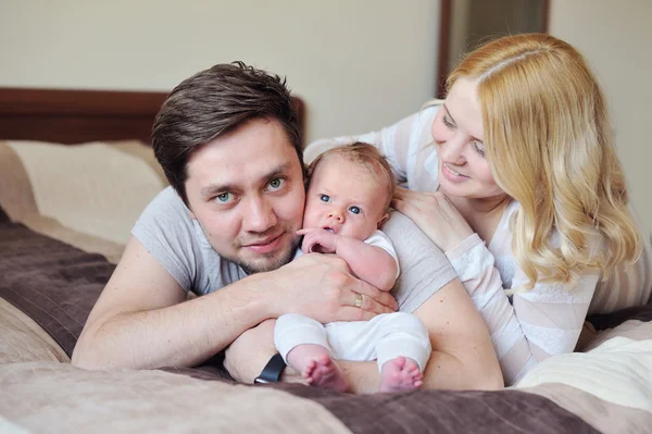 Glückliche junge attraktive Familieneltern mit Neugeborenem — Stockfoto