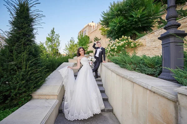 Mariée et marié monter les escaliers dans le parc — Photo