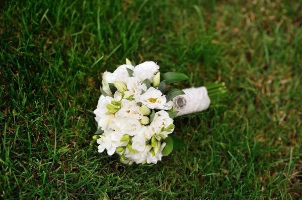 Yeşil çimenlerin üzerinde beyaz gelin düğün buketi — Stok fotoğraf