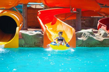 beautiful young woman pulls off the slides in water park