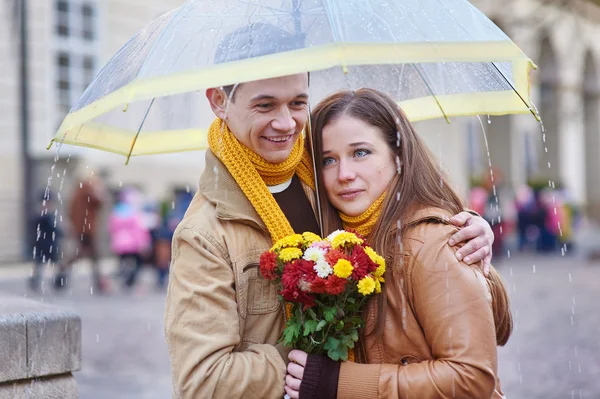 Bonito jovem casal amoroso sob um guarda-chuva na chuva — Fotografia de Stock