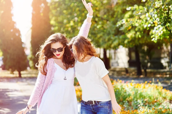Two young happy women walking in the summer city — Stock Photo, Image