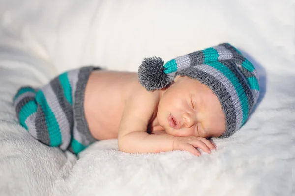 Mały chłopiec dziecko w czapka leżąc na łóżku — Zdjęcie stockowe