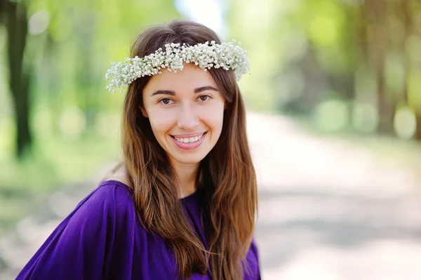 Mooie lachende vrouw met een kroon op zijn hoofd in de zomer park — Stockfoto