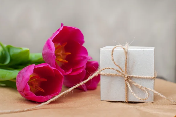 Tre tulipano viola e una scatola per regalo — Foto Stock