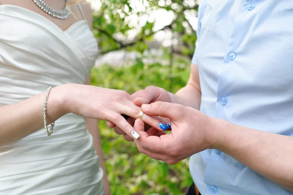 Bruden brudgummen klänningar en vigselring på fingret — Stockfoto