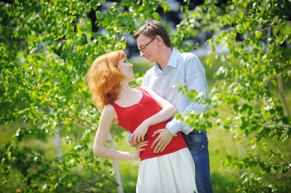 Hermosa joven pareja amorosa abrazando en flor jardín de primavera — Foto de Stock