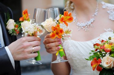 Gelin ve damat şampanya bardağı tutuyor