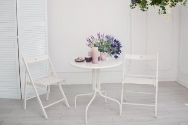 Bir buket çiçek ve odasında iki sandalye beyaz masa