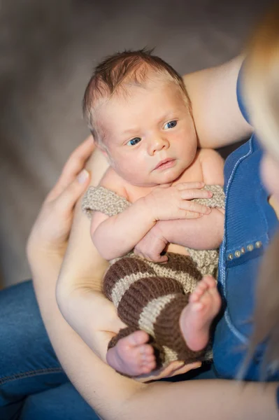 Junge Mutter hält ihren kleinen Sohn in den Armen — Stockfoto