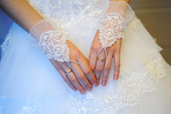 Spose mani in guanti a rete su sfondo abito da sposa — Foto Stock