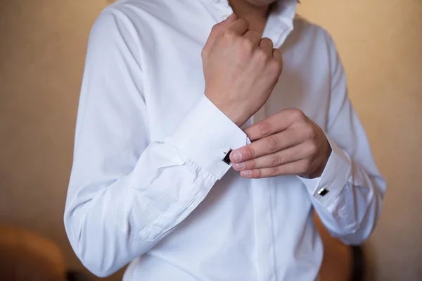 Groom wears cuff links on white shirt — Stock Photo, Image