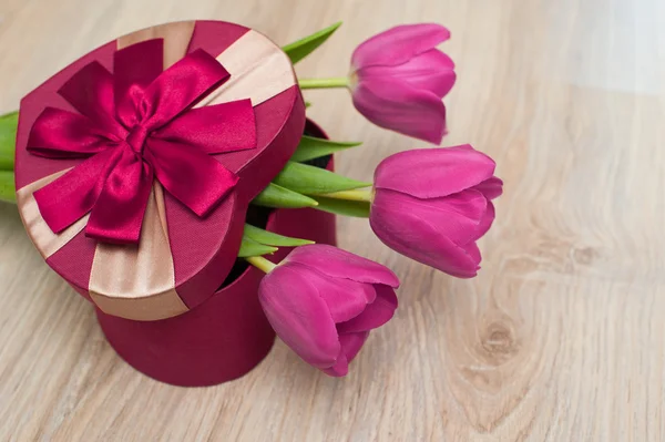 Tres tulipanes y caja roja para regalo en forma de corazón — Foto de Stock