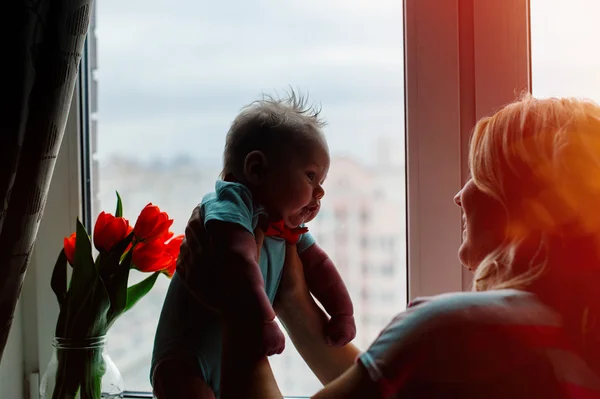 美しい若い母親が幼い息子を保持しています。 — ストック写真