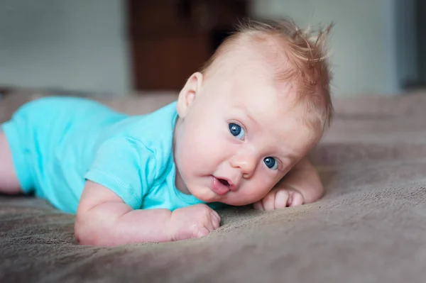 Bambino piccolo sdraiato su morbida coperta in camera — Foto Stock