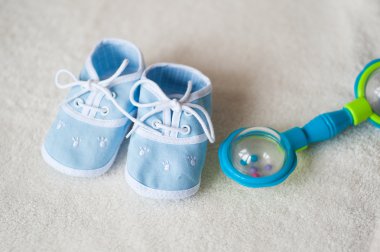 Bebek Patik ve rattle ışık arka plan üzerinde