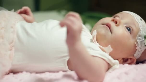 Happy babymeisje liggend op roze deken — Stockvideo