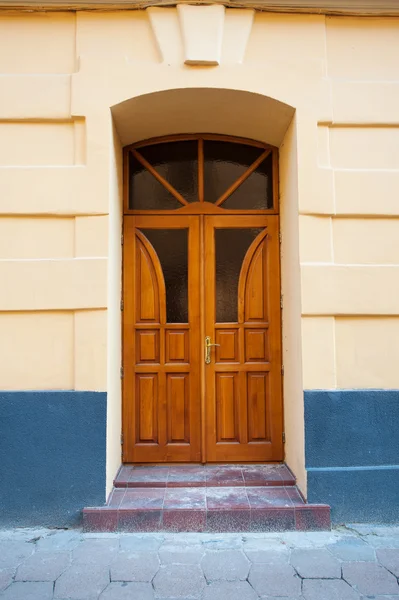 Starodawny stary drewniane drzwi w ścianie łuku — Zdjęcie stockowe