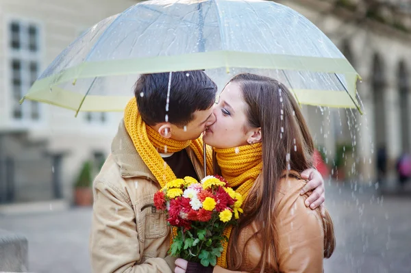 Closeup of young beautiful couple kissing under umbrella — Stock Photo, Image