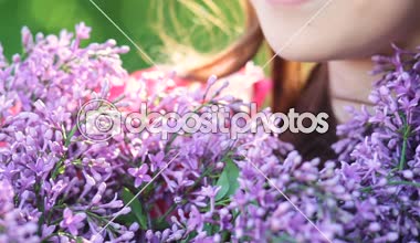 Güzel gülümseyen genç kadın elinde Açık Eflatun çiçek buketi ile