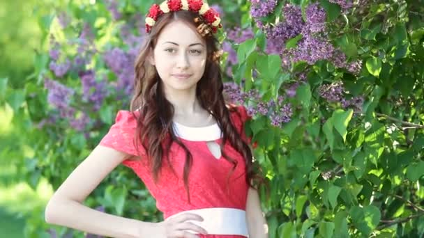Hermosa mujer cerca de lila en el parque de primavera — Vídeo de stock