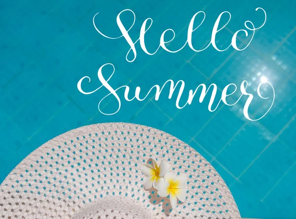Twee plumeria bloem op hoed tegen de achtergrond van het zwembad en/of letters Hallo zomer — Stockfoto