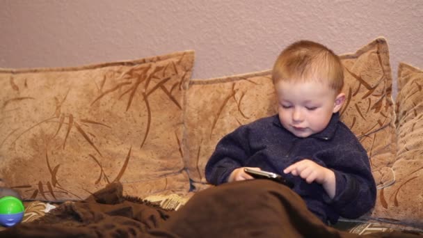 Niño juega juego en un teléfono inteligente — Vídeo de stock