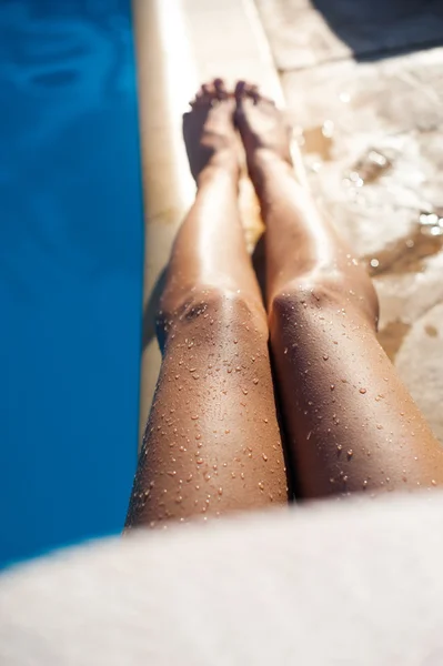 Swimminp havuz kenarında güzel uzun tabaklanmış kadın bacaklar — Stok fotoğraf