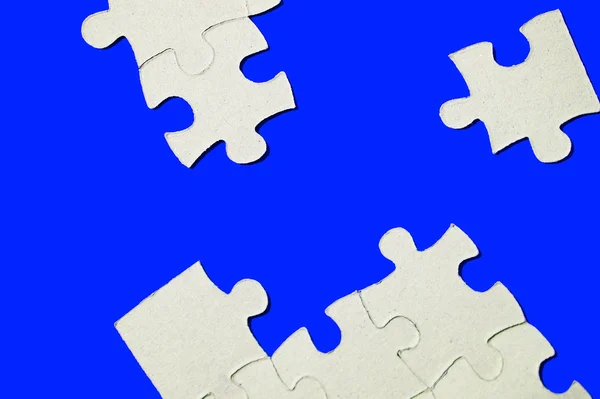Karton puzzle kawałki na niebieskim tle — Zdjęcie stockowe