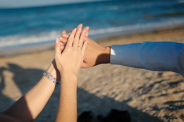 Young adult male groom and female bride holding hands on beach — Stock Photo, Image