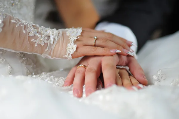 Hände von Braut und Bräutigam mit Ringen am Kleid — Stockfoto