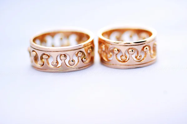 Два золотых обручальных кольца на белом фоне крупного плана — стоковое фото
