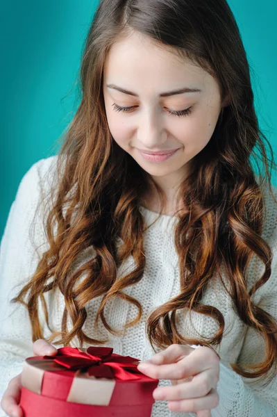 Woman opens a red gift in form of heart — Stock Photo, Image