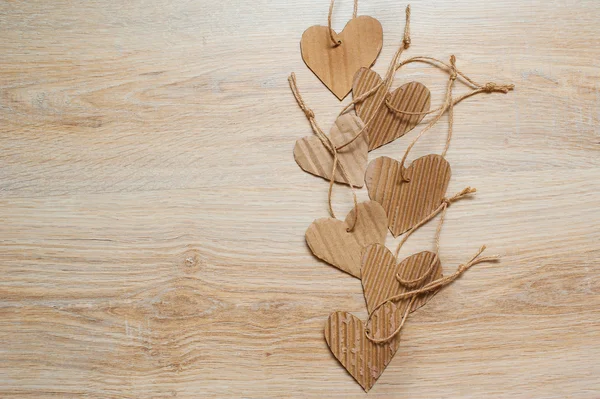 Cuori di carta Kraft fatti a mano su texture di sfondo in legno — Foto Stock