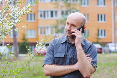 telefon çok öykülü bir binanın arka planda olan adam