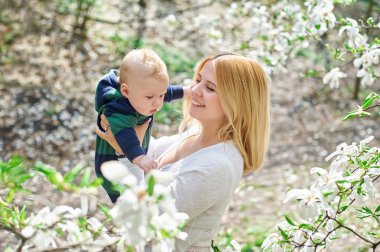 Küçük oğlu genç annesiyle çiçek açması bahar bahçe