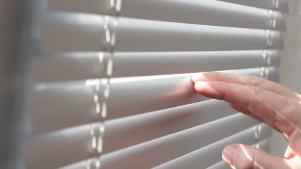 Man looking through window blinds — Stock Video