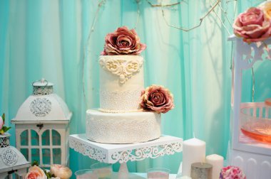 Beyaz düğün pastası dekore edilmiş şeker desen masada