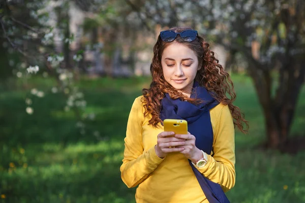 Teknik och människor koncept - leende ung kvinna textning på smartphone — Stockfoto