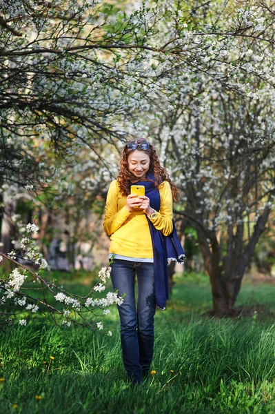 技術と人のコンセプト - スマート フォンで若い女性のテキスト メッセージを笑顔 — ストック写真