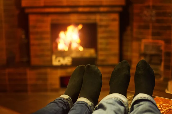 暖炉のそばの男性と女性の脚。家族の概念 — ストック写真