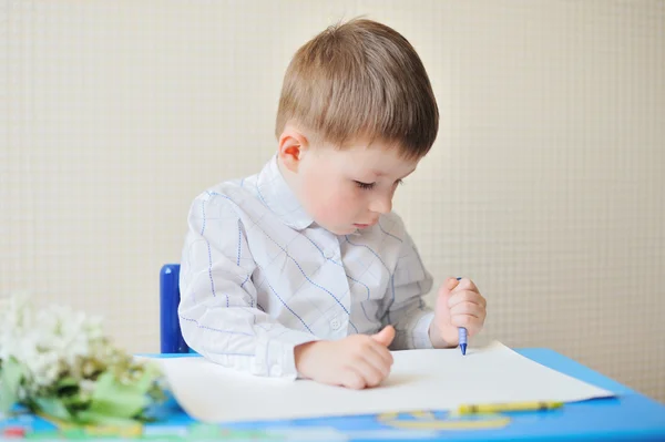 可爱的男孩在教室里的桌子上的纸和笔的肖像 — 图库照片